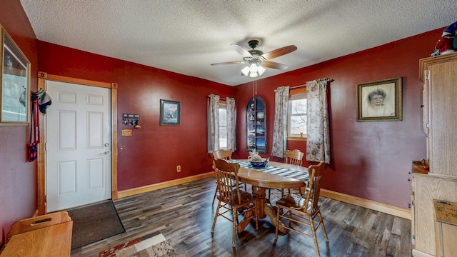 dining space with a ceiling fan, a textured ceiling, baseboards, and wood finished floors