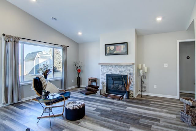 living area featuring a fireplace, recessed lighting, vaulted ceiling, wood finished floors, and baseboards