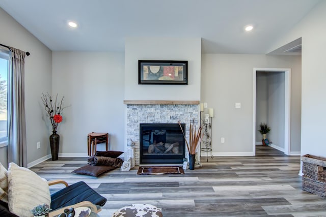 living room with a fireplace, baseboards, wood finished floors, and recessed lighting