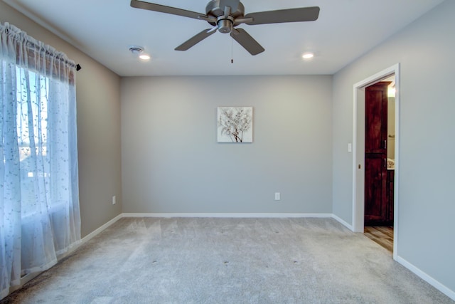 empty room featuring a ceiling fan, recessed lighting, light colored carpet, and baseboards