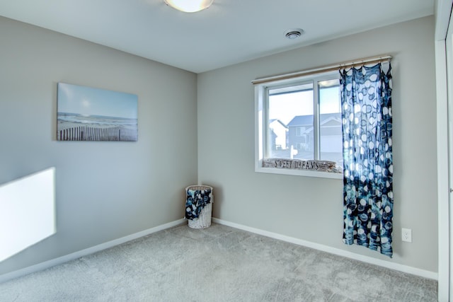 empty room with light carpet, visible vents, and baseboards