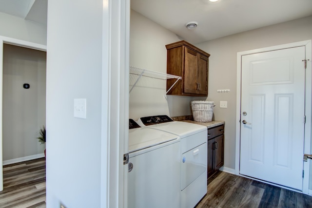 laundry area featuring cabinet space, dark wood finished floors, baseboards, and separate washer and dryer