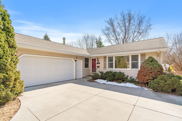 single story home with concrete driveway, a garage, and a shingled roof