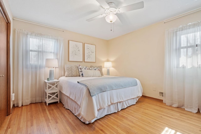 bedroom featuring visible vents, baseboards, wood finished floors, and a ceiling fan