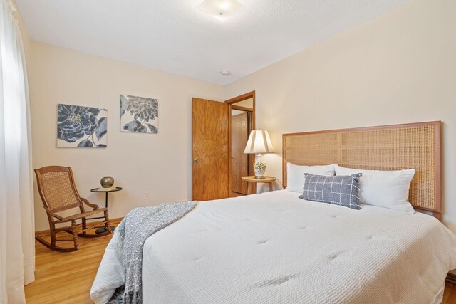 bedroom featuring baseboards and wood finished floors