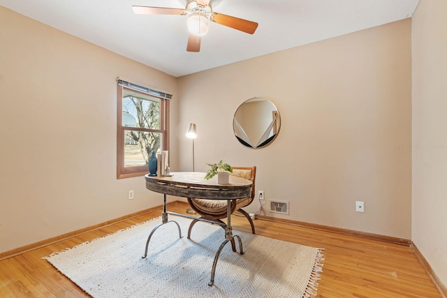 home office with ceiling fan, visible vents, baseboards, and light wood-style flooring