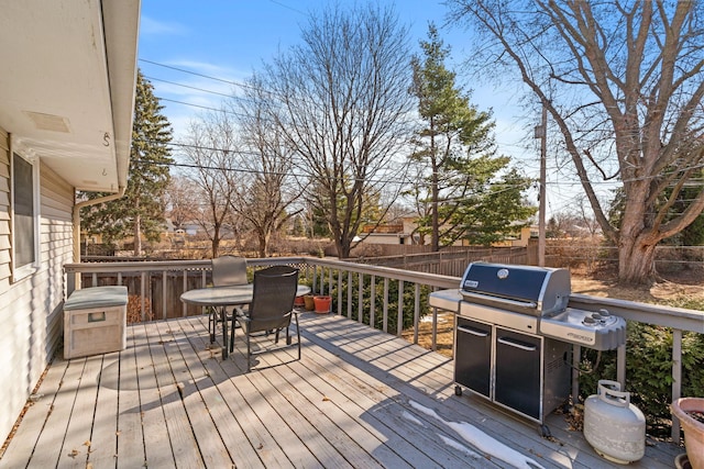 wooden terrace with outdoor dining area and fence