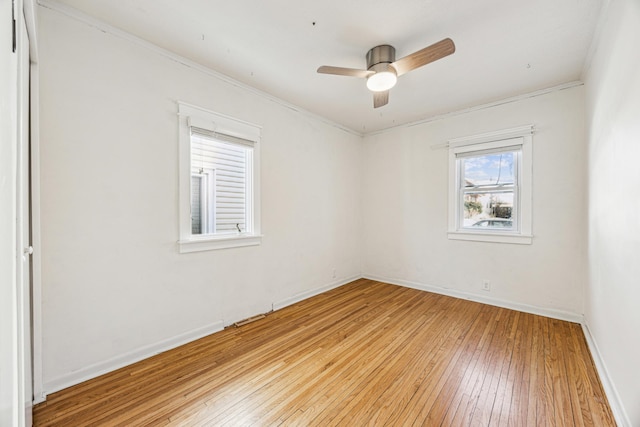 empty room with light wood finished floors, baseboards, and a ceiling fan