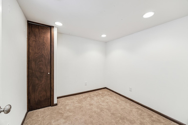 unfurnished room featuring recessed lighting, light carpet, and baseboards