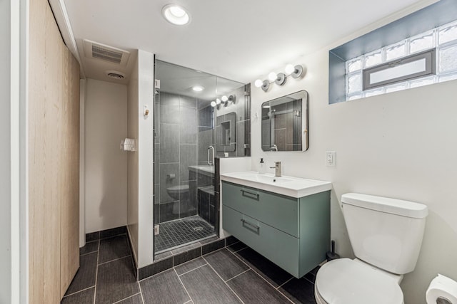 bathroom with a stall shower, visible vents, vanity, and toilet