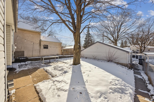 snowy yard with a patio and a fenced backyard