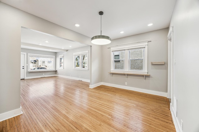 unfurnished living room with recessed lighting, baseboards, and light wood finished floors