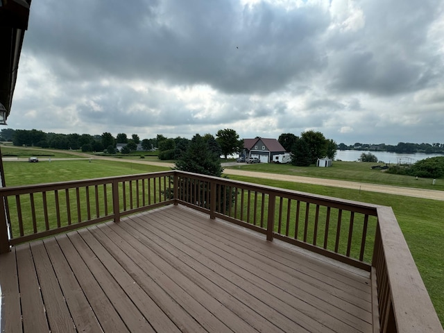 wooden terrace featuring a lawn and a water view