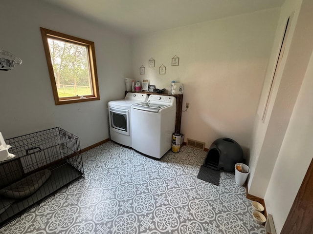 laundry area featuring laundry area, baseboards, visible vents, and washing machine and clothes dryer