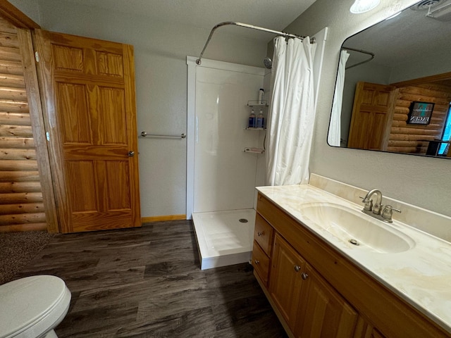 full bath with rustic walls, a shower stall, and wood finished floors