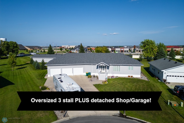 ranch-style home with an attached garage, concrete driveway, a front lawn, and a shingled roof