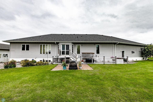 rear view of property with a patio, a yard, and a shingled roof