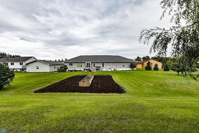 rear view of house with a garden and a lawn