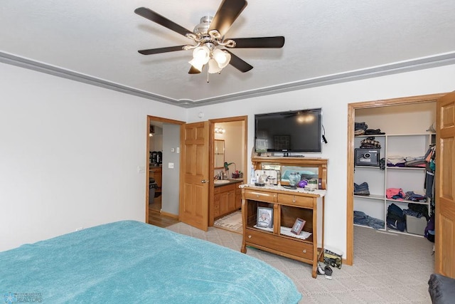 bedroom featuring a ceiling fan, a walk in closet, a closet, and ensuite bath