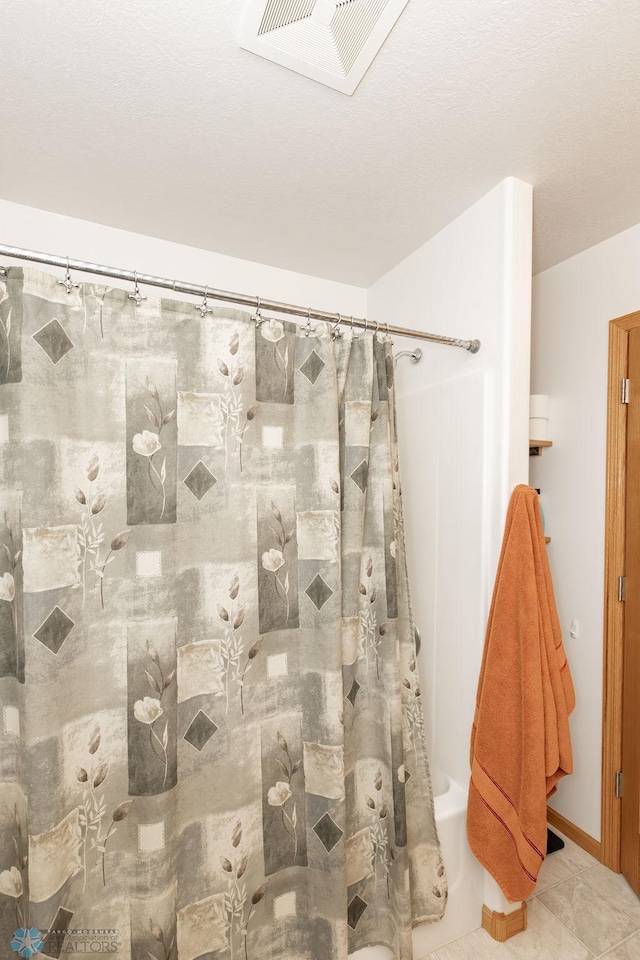 bathroom featuring shower / bath combination with curtain, tile patterned flooring, and visible vents