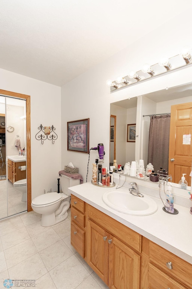 full bath with vanity, toilet, and tile patterned floors