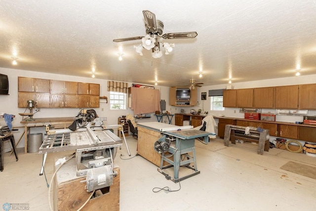 kitchen with a healthy amount of sunlight, concrete floors, light countertops, and a ceiling fan