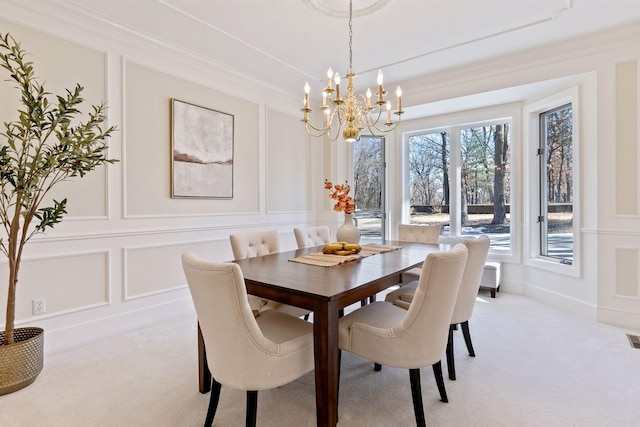 dining room with crown molding, light carpet, and a decorative wall