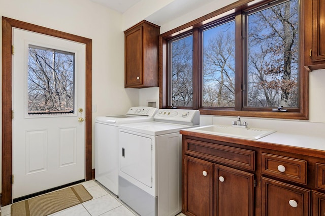 laundry area with light tile patterned floors, cabinet space, a sink, and separate washer and dryer