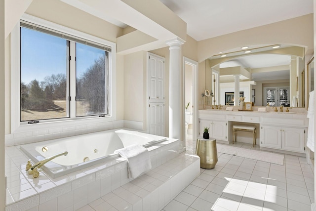 bathroom with plenty of natural light, a jetted tub, ornate columns, and double vanity