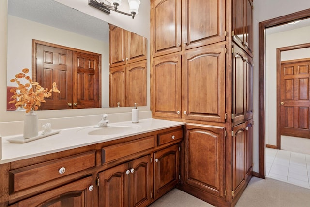 bathroom with tile patterned floors, a closet, and vanity