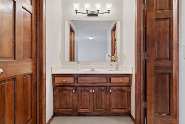 bathroom featuring a closet, vanity, and baseboards