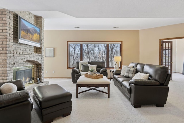 living room with light carpet, a brick fireplace, visible vents, and baseboards