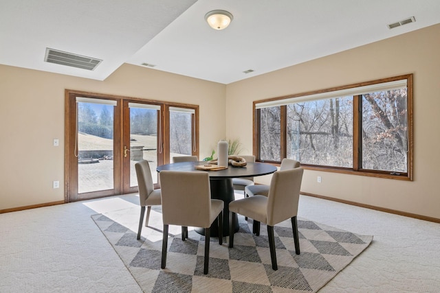 dining room with light carpet, baseboards, and visible vents