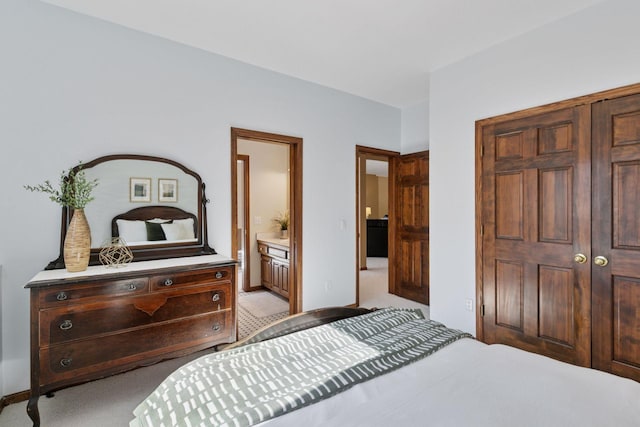 bedroom with light carpet, ensuite bath, baseboards, and a closet