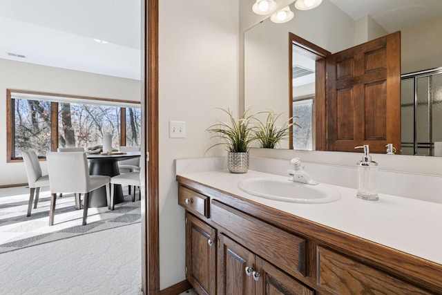 full bath with visible vents, a shower with shower door, and vanity