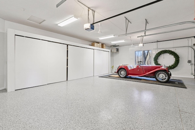 garage featuring a wall mounted air conditioner and a garage door opener