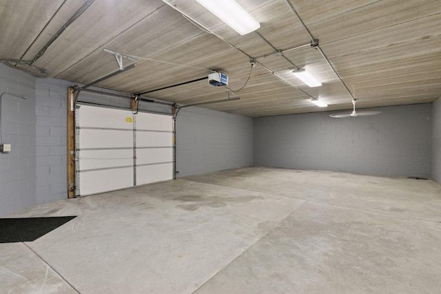 garage with concrete block wall and a garage door opener