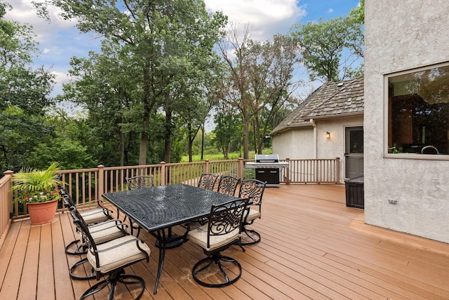 deck featuring outdoor dining area and grilling area