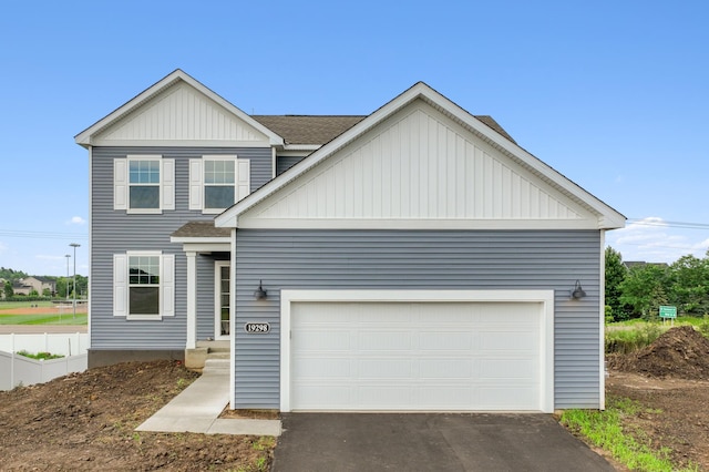 view of front facade with a garage, aphalt driveway, board and batten siding, and roof with shingles