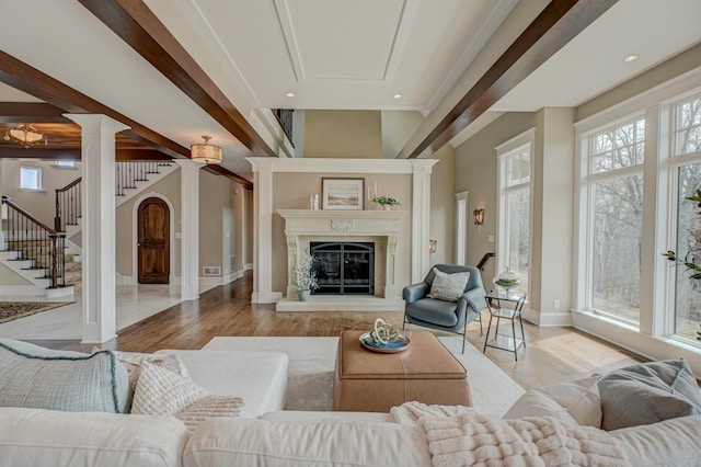 795 140th Ave, New Richmond, WI 54017 - living area featuring ornate columns, stairway, wood finished floors, baseboards, and a glass covered fireplace