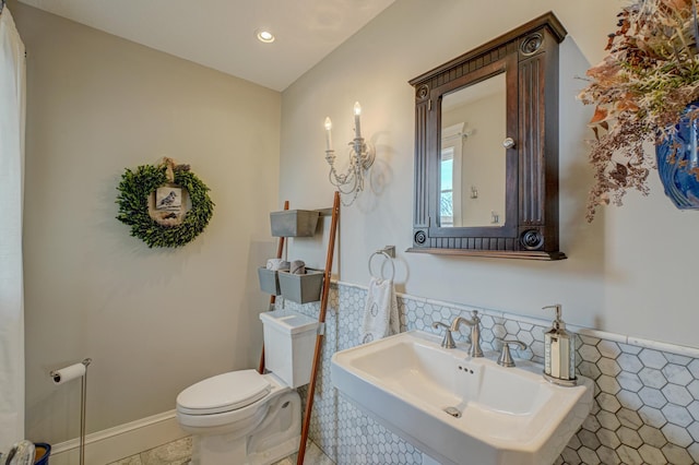 795 140th Ave, New Richmond, WI 54017 - bathroom featuring a sink, toilet, tile walls, wainscoting, and recessed lighting