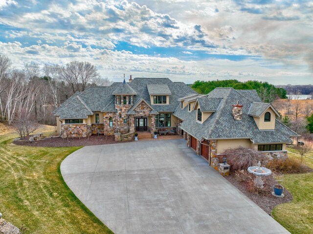 795 140th Ave, New Richmond, WI 54017 - view of front of house featuring stone siding, driveway, stucco siding, a garage, and a front yard