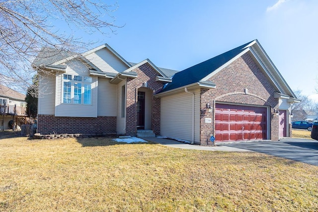 traditional-style home featuring a garage, a front yard, aphalt driveway, and brick siding