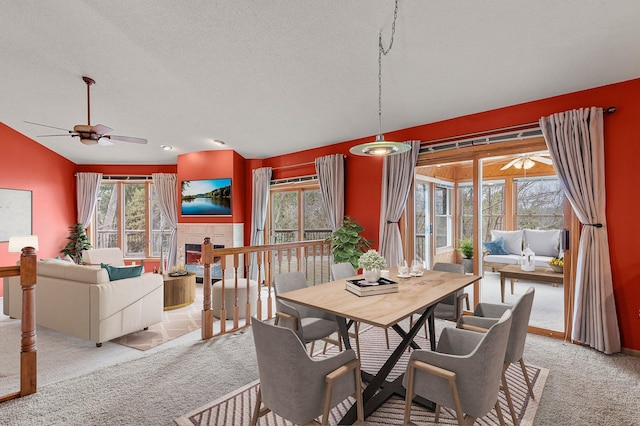 dining area featuring light carpet, a ceiling fan, and a textured ceiling