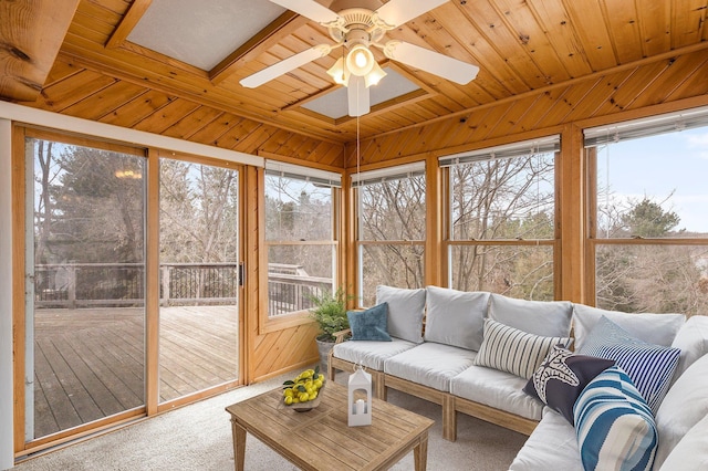 sunroom / solarium featuring wooden walls, carpet, wooden ceiling, and a deck