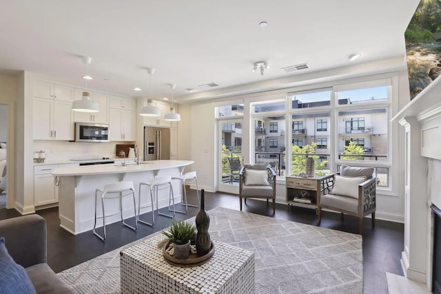 living room with dark wood-style floors, baseboards, visible vents, and recessed lighting