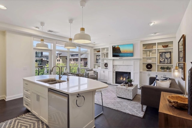 kitchen with visible vents, light countertops, white cabinetry, a sink, and a high end fireplace