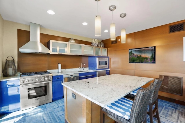 kitchen featuring visible vents, appliances with stainless steel finishes, blue cabinets, a sink, and exhaust hood