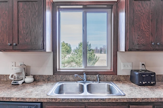 kitchen with dishwasher, a sink, and dark brown cabinetry