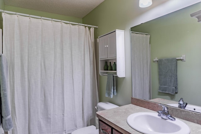 full bathroom featuring a textured ceiling, a shower with shower curtain, vanity, and toilet